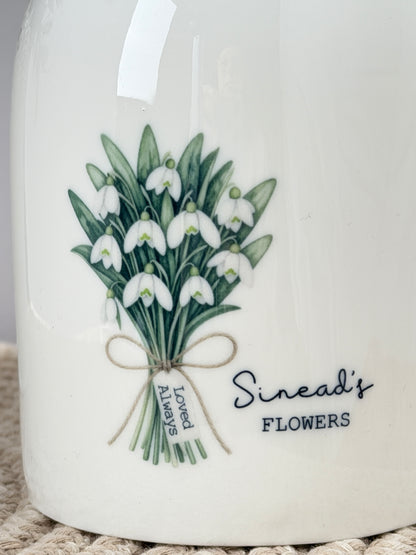 Close-up of personalised January birth flower jug showing the watercolour snowdrop design, custom name and mini message tag