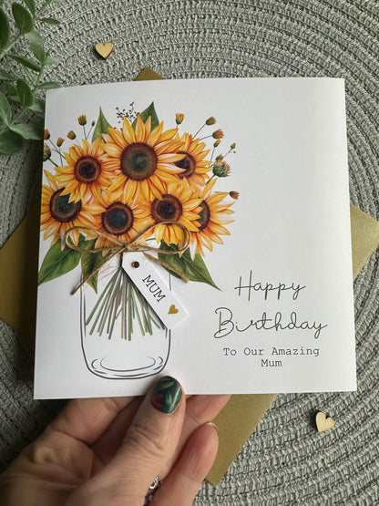 Hand holding a matching birthday card with sunflowers which can be personalised with the wording of your choice.