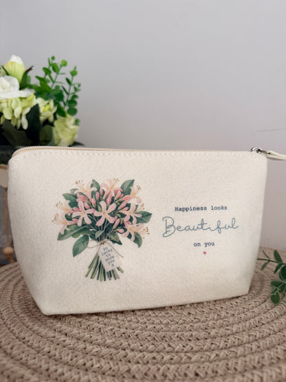 Personalised cream felt makeup and accessory bag with a pink floral bouquet design and the words “Happiness Looks Beautiful on You”.