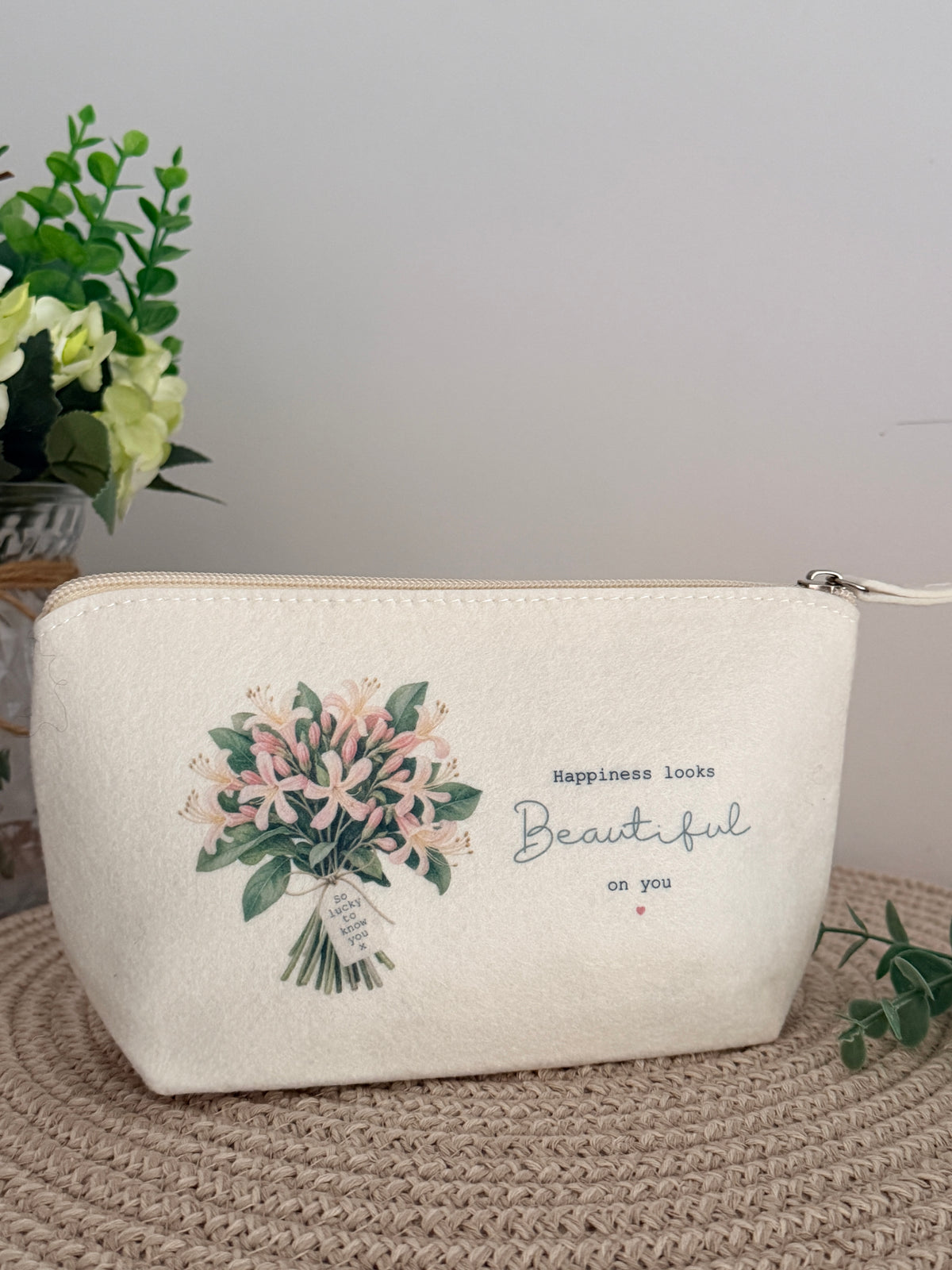 Personalised cream felt makeup and accessory bag with pink floral bouquet and “Happiness Looks Beautiful on You” wording.