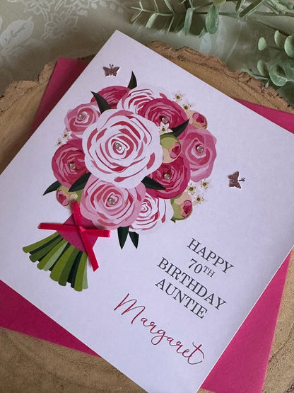A personalised birthday card with a pink flower bouquet design, including a name and a message, with a pink envelope.